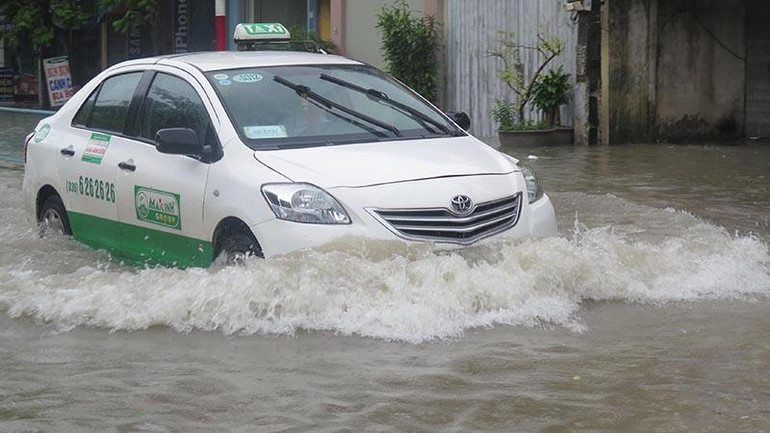 Một số ô-tô di chuyển trên đường Phạm Đôn Lễ (thành phố Thái Bình) khi nước mấp mé gần nửa bánh xe.