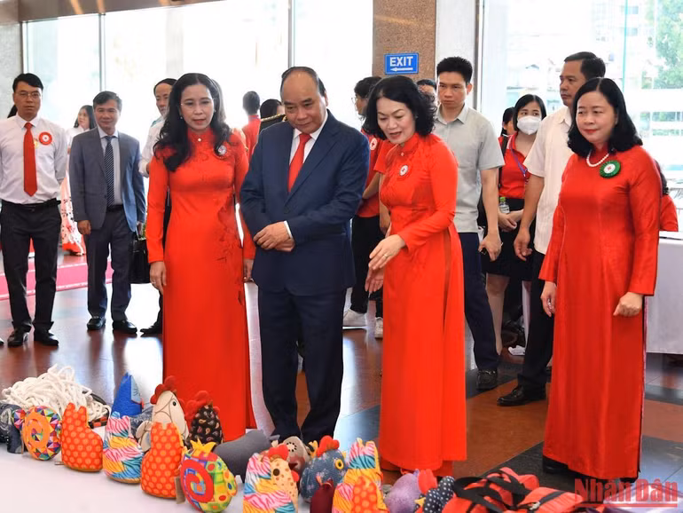 Chủ tịch nước Nguyễn Xuân Phúc tham quan gian hàng của Công ty Kym Việt, một trong những doanh nghiệp xã hội có lao động là người khuyết tật.