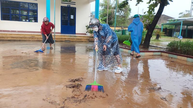 Các giáo viên trường Tiểu học số 2 Hòa Liên tranh thủ thời gian nước vừa rút, tổ chức dọn vệ sinh môi trường. (Ảnh: HỒ VĂN)