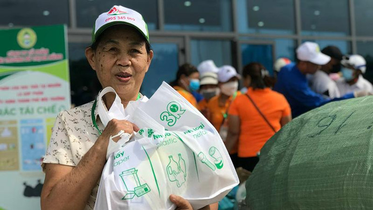 Niềm vui của một người dân sau khi tham gia chương trình đổi rác lấy quà tặng.