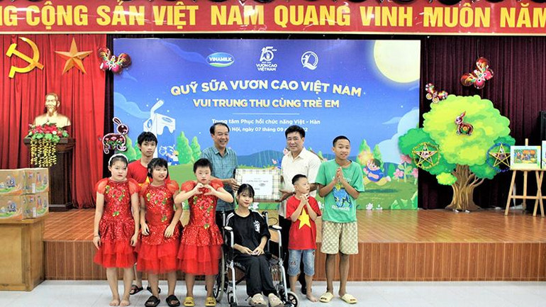 Ông Nguyễn Kim Cam, Giám đốc Trung tâm Phục hồi chức năng Việt-Hàn nhận món quà trung thu từ đại diện Quỹ bảo trợ trẻ em Việt Nam.