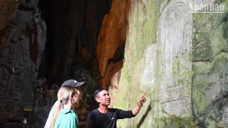 Du khách Cameron và bạn đến từ Úc, đang tìm hiểu Ma nhai Nam Bảo Đài hình bi tại Động Tang Chơn, sáng ngày 29/11.