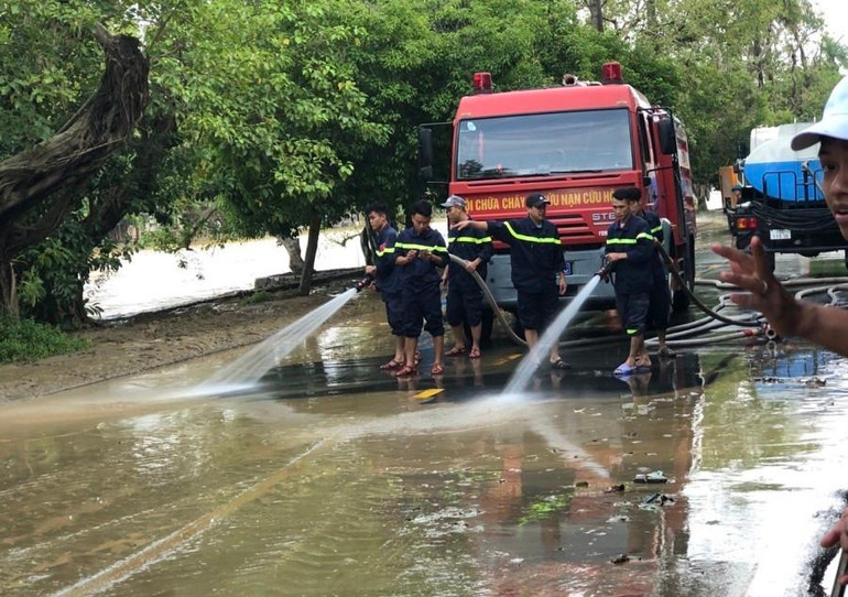 Lực lượng phòng cháy, chữa cháy và cứu nạn cứu hộ Công an tỉnh dùng phương tiện xe phun nước làm sạch các tuyến phố sau lũ.