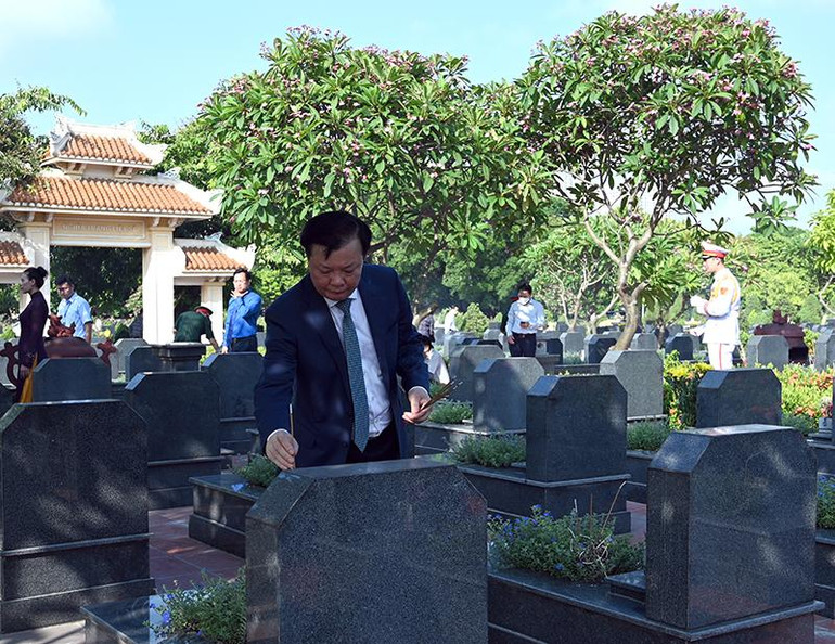 Bí thư Thành ủy Đinh Tiến Dũng thắp hương trên các phần mộ liệt sĩ tại nghĩa trang.