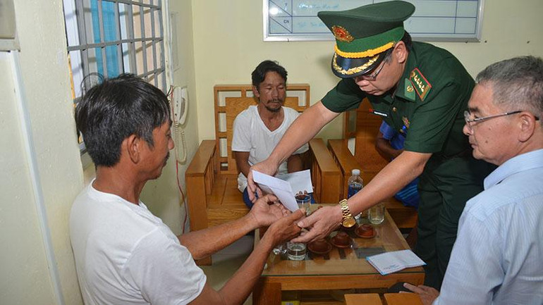 Đại diện Bộ Chỉ huy Bộ đội Biên phòng tỉnh Bình Thuận tặng quà cho ngư dân được cứu vào bờ an toàn.