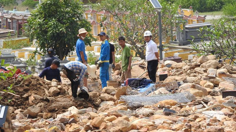 Người dân đào bới đất đá, tìm mộ người thân ở nghĩa trang Hòa Sơn.