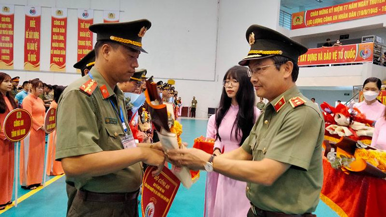 Trung tướng Nguyễn Ngọc Toàn (bên phải), Cục trưởng Cục Công tác Đảng và Công tác Chính trị Bộ Công an tặng hoa và cờ lưu niệm cho các đơn vị tham gia Hội thao ứng dụng nghiệp vụ lực lượng Công an nhân dân năm 2022.