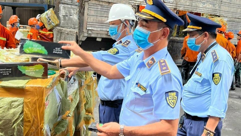 Lực lượng chức năng chứng kiến và giám sát việc tiêu hủy lô hàng hóa vi phạm.