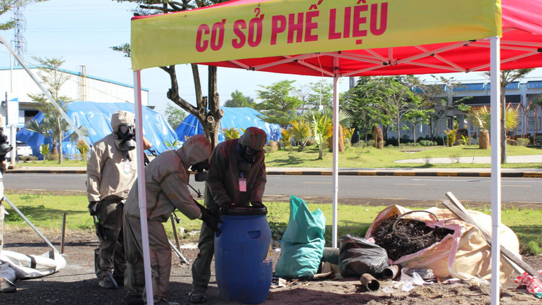 Lực lượng quân đội tiến hành tẩy xạ và thu gom vật liệu đất đá, phế liệu vào thùng chứa chuyên dụng.