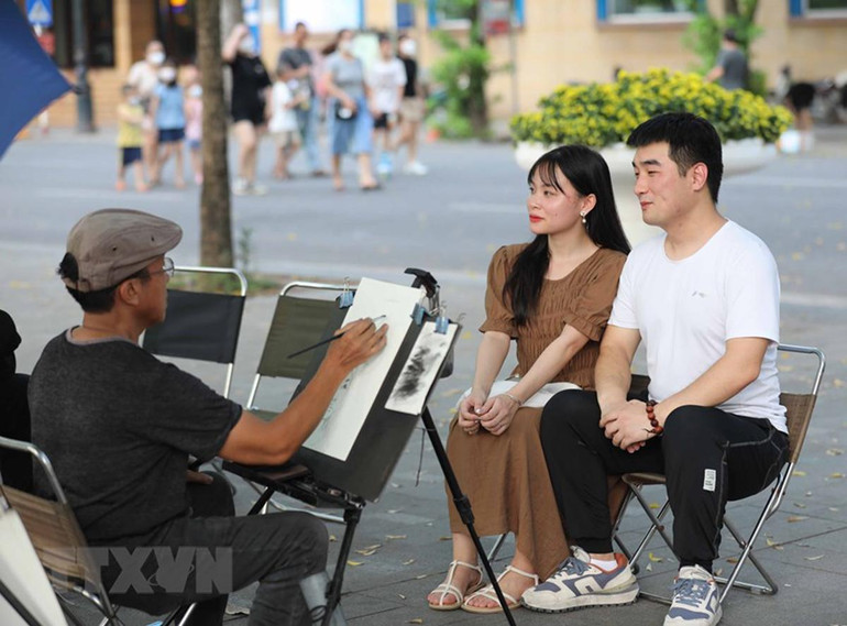 Du khách trải nghiệm vẽ truyền thần trong không gian đi bộ hồ Hoàn Kiếm. (Ảnh: Thanh Tùng/TTXVN) Du khách trải nghiệm vẽ truyền thần trong không gian đi bộ hồ Hoàn Kiếm. (Ảnh: Thanh Tùng/TTXVN)