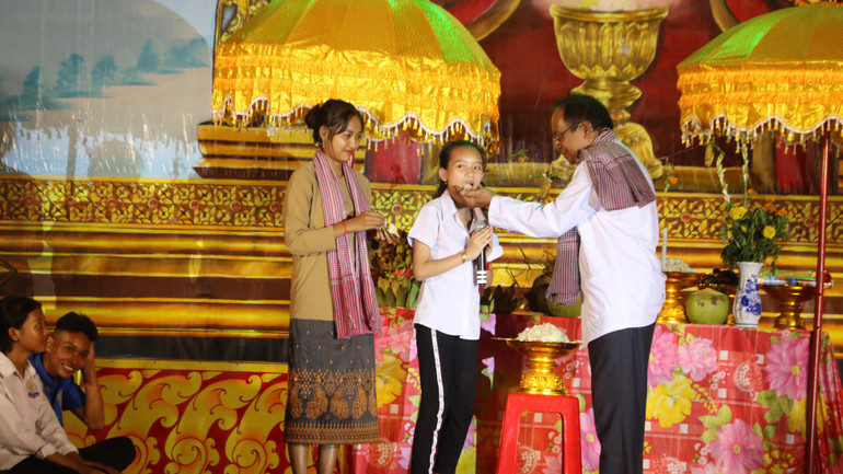 Các nghệ nhân chùa Khmer xã Bình Phú, huyện Càng Long kể câu chuyện ý nghĩa lễ cúng trăng và thực hiện nghi thức đút cốm dẹp cho trẻ em.