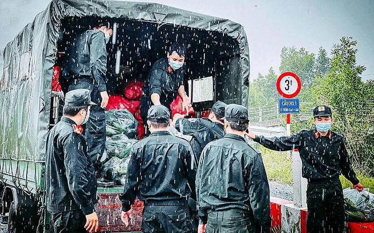 Cán bộ, chiến sĩ công an hỗ trợ người dân tiêu thụ nông sản trong đại dịch Covid-19.