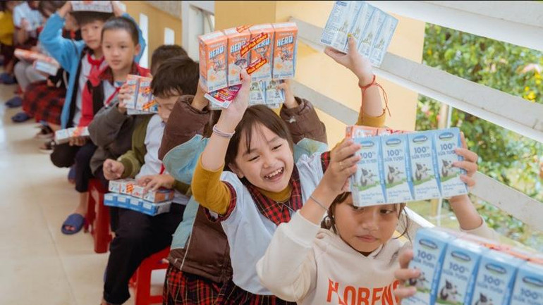 Các em học sinh tại Quảng Nam và Huế vui mừng khi nhận sữa Vinamilk từ đoàn hỗ trợ.