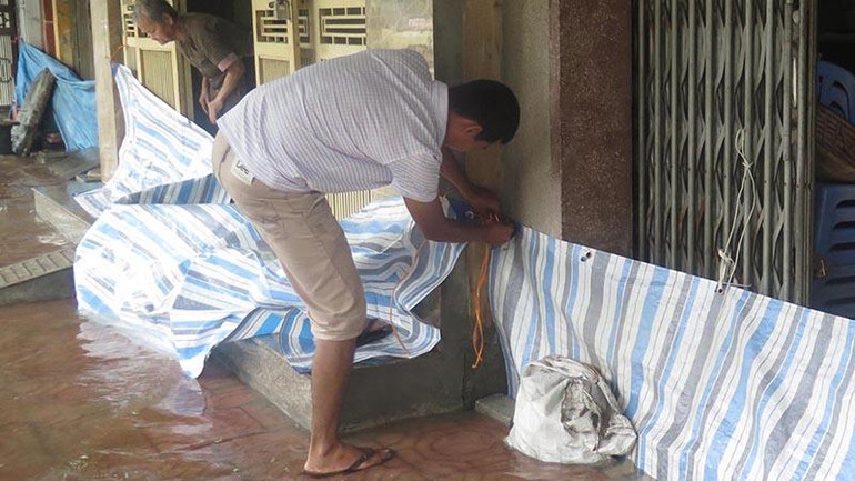 Các hộ dân trên phố Lê Quý Đôn (thành phố Thái Bình) dùng đủ mọi vật dụng để ngăn nước vào nhà.