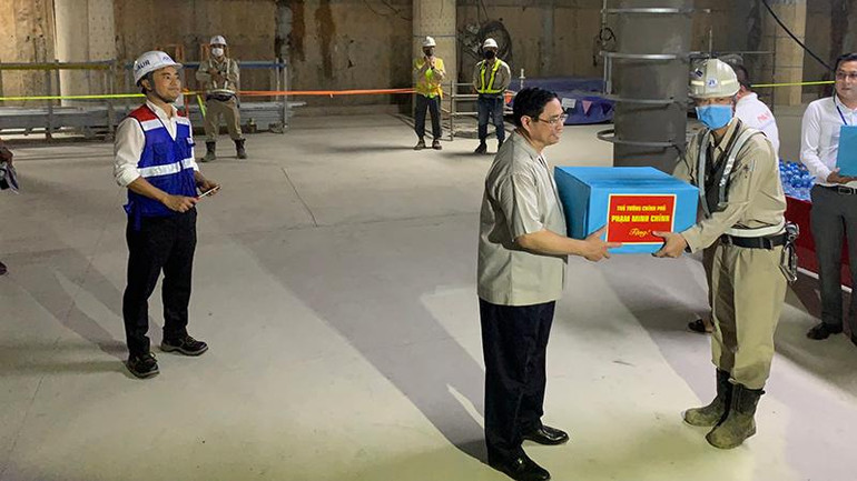 Thủ tướng Phạm Minh Chính trao quà cho công nhân và kỹ sư tại công trường.