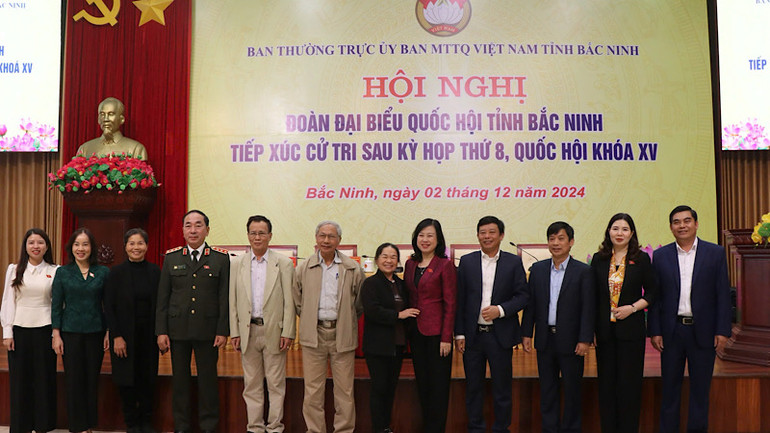 Cử tri trao đổi, chụp ảnh kỷ niệm với các đại biểu Quốc hội.