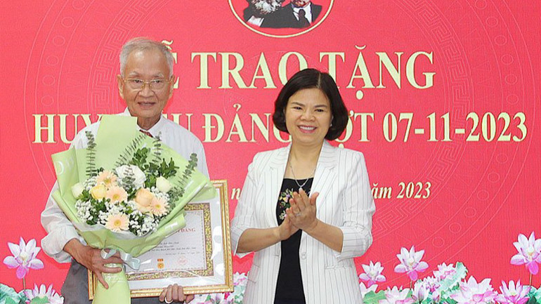 Chủ tịch Ủy ban nhân dân tỉnh Bắc Ninh Nguyễn Hương Giang trao Huy hiệu 60 năm tuổi Đảng tặng đảng viên Vũ Đức Trung, ở phường Suối Hoa, thành phố Bắc Ninh.