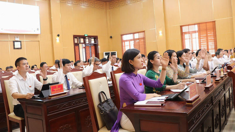 Các đại biểu Hội đồng nhân dân tỉnh biểu quyết thông qua các Nghị quyết.