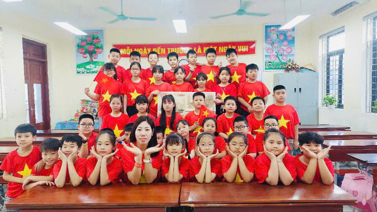 Cô và trò trường Tiểu học Ninh Xá, thành phố Bắc Ninh check-in cùng phụ san đặc biệt của Báo Nhân Dân.