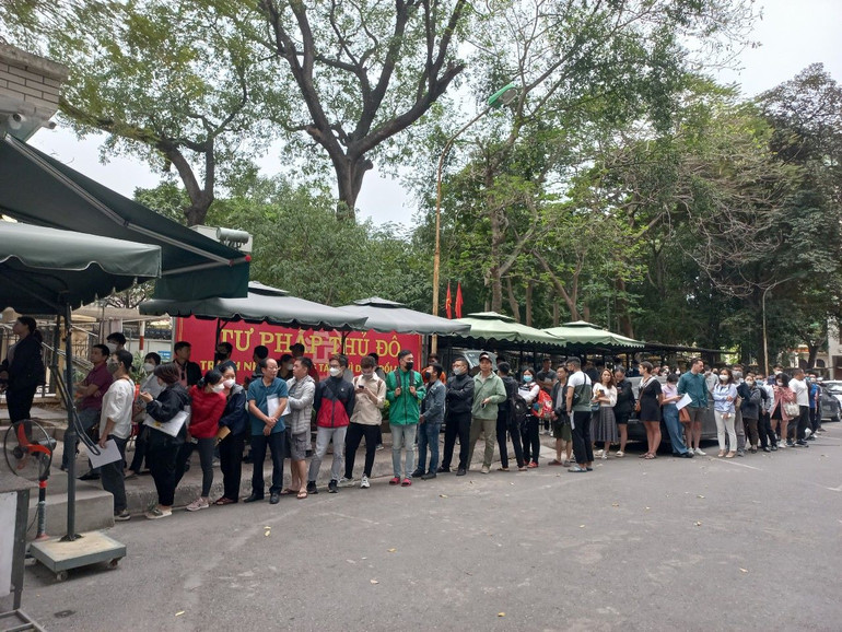 Công dân xếp hàng lấy số thứ tự trong khuôn viên Sở Tư pháp. ( Ảnh: HNM)