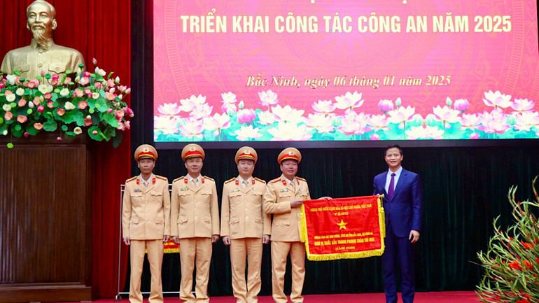 Đồng chí Vương Quốc Tuấn trao Cờ thi đua của Chính phủ tặng Phòng Cảnh sát giao thông, Công an tỉnh.
