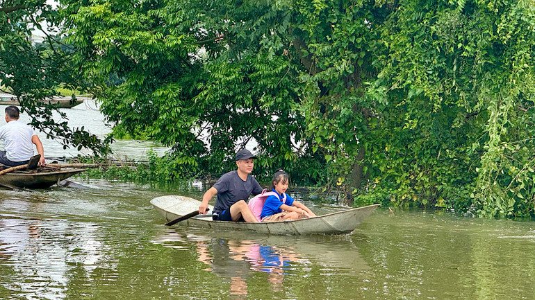 Học sinh vùng lũ vẫn đi thuyền tới trường.