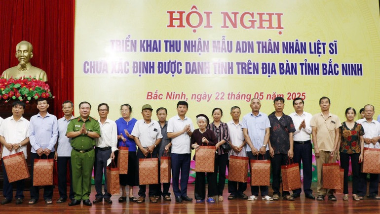 Các đại biểu trao quà tặng các thân nhân liệt sĩ.