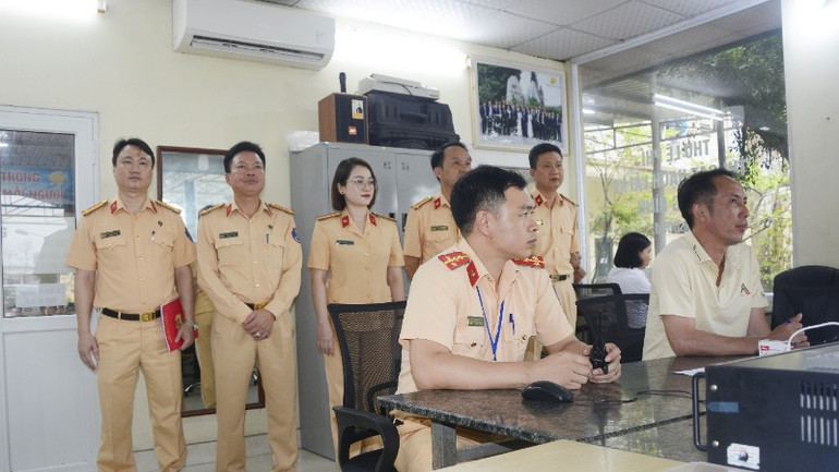 Lãnh đạo Phòng Cảnh sát Giao thông (Công an tỉnh) kiểm tra công tác tổ chức phần thi sát hạch lái xe trong hình tại nhà điều hành.