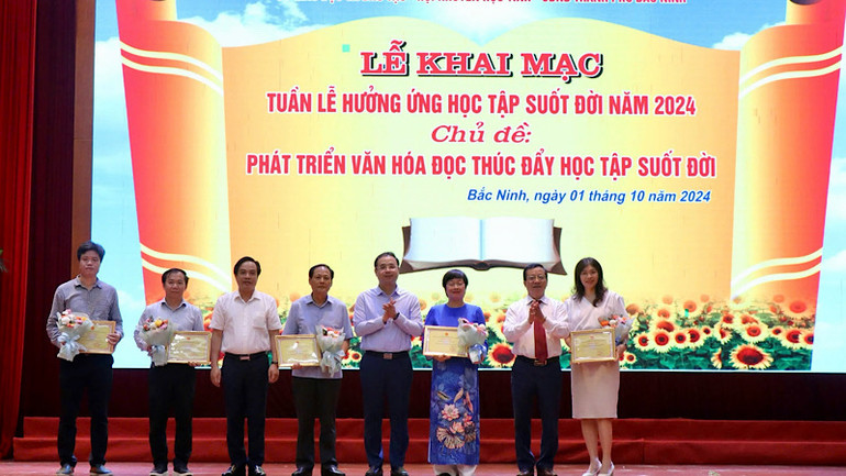 Ban tổ chức trao giấy chứng nhận, tặng hoa cảm ơn các đơn vị tặng sách.