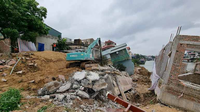 Lực lượng chức năng khắc phục sự cố, giảm tải cho đê và khơi thông dòng chảy. (Ảnh chụp tháng 4/2024).