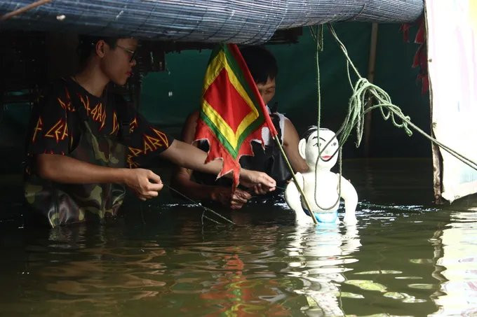 Nhật Minh (bên trái) tham gia múa rối nước dành cho các em nhỏ hoàn cảnh khó khăn. (Ảnh: NVCC)