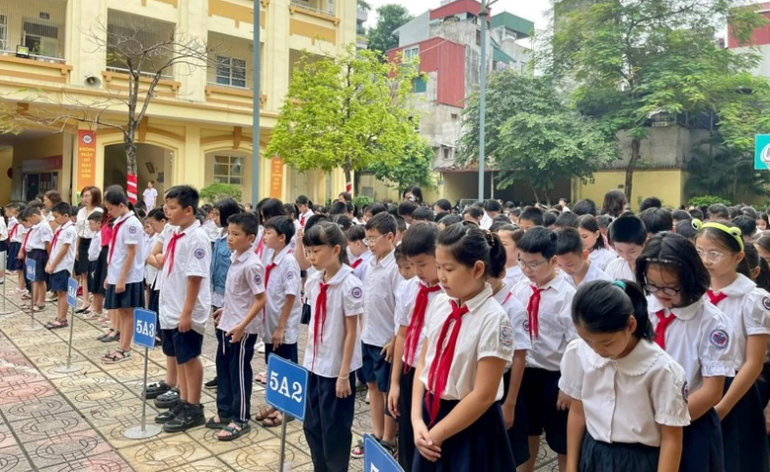 Học sinh trường liên cấp Khương Hạ, quận Thanh Xuân dành phút tưởng niệm cho những người không may qua đời trong vụ cháy chung cư mini tại Khương Hạ hôm 12/9. (Ảnh: Ngọc Khánh)