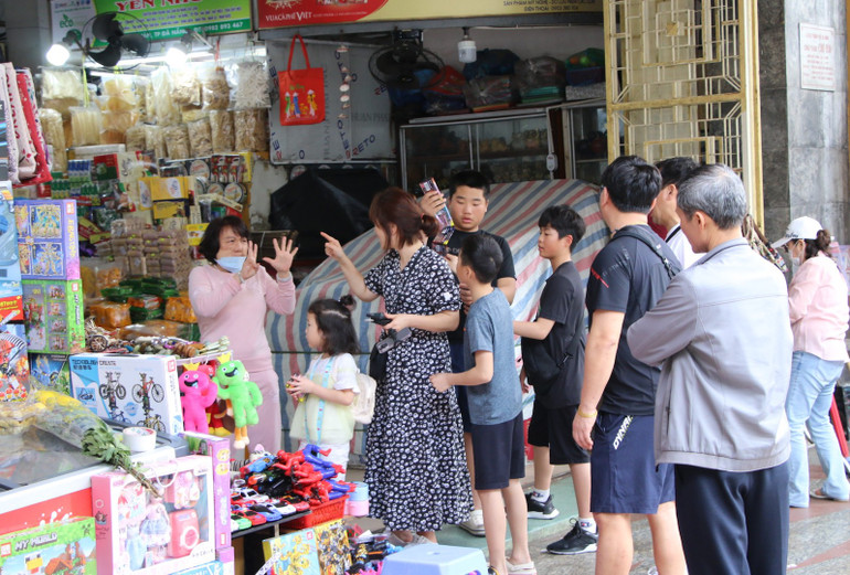 Khách du lịch và tiểu thương trao đổi giá cả. Khách du lịch và tiểu thương trao đổi giá cả.