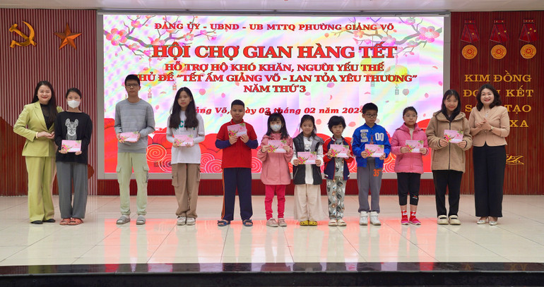 Lãnh đạo quận Ba Đình và phường Giảng Võ tặng quà cho các cháu học sinh nghèo vượt khó vươn lên trong học tập.