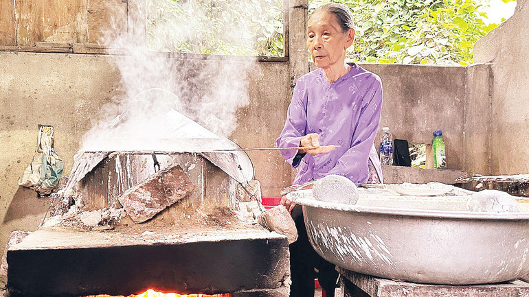 Nghệ nhân Đặng Thị Túy Phong thực hiện công đoạn tráng bánh.