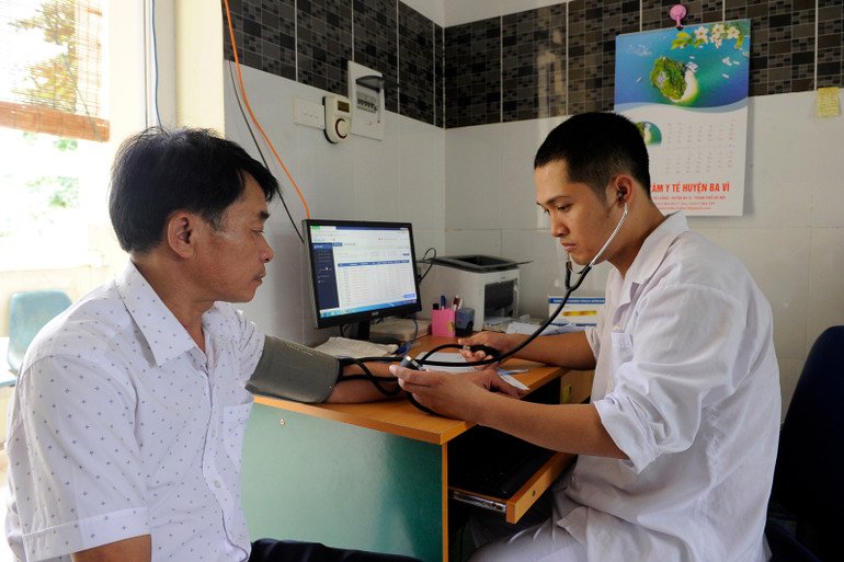 Bác sĩ Trạm y tế xã Ba Trại, huyện Ba Vì (Hà Nội) khám bệnh cho người dân. (Ảnh TUỆ NGHI)