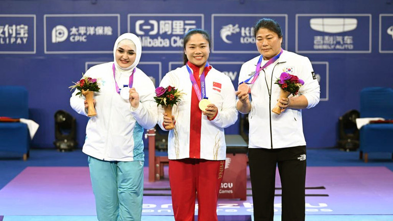 VĐV Tan Yujiao (giữa) lập kỷ lục thế giới mới ở môn cử tạ hạng dưới 67kg nữ. (Ảnh XINHUA)