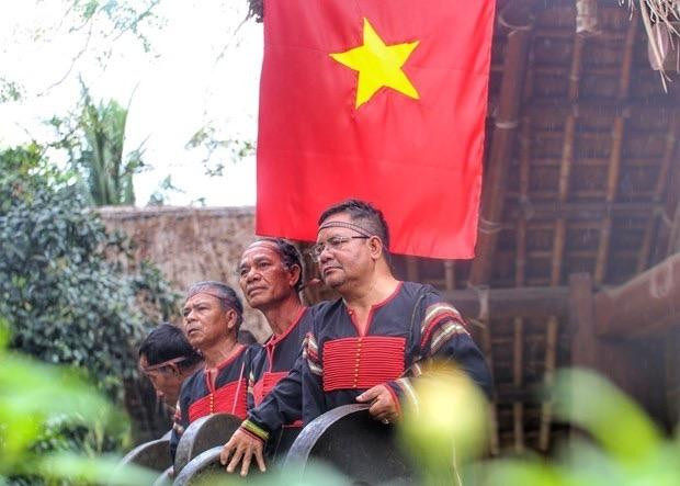 Các nghệ nhân hoà bài chiêng “Drông tuê’’ tức là Đón khách. Đây là bài chiêng báo cho các vị thần và linh hồn ông bà - những người đã khuất về chứng giám và phù hộ cho gia đình, đồng thời thông báo và mời gọi họ hàng của hai gia đình cùng về dự lễ, chứng kiến, chung vui trong lễ nhận con nuôi.