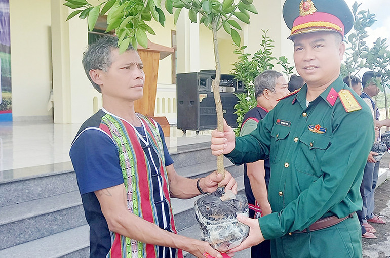 Đại diện Đoàn Kinh tế-Quốc phòng 207 trao cây giống tặng người dân huyện Nam Giang.