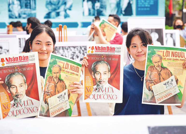 Các bạn trẻ hào hứng cầm trên tay ấn phẩm đặc biệt của Báo Nhân Dân.