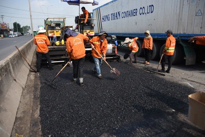Trải lớp nhựa nóng lên đoạn đường hư hỏng nghiêm trọng.
