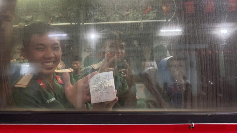 Chiến sĩ chào người dân địa phương khi đoàn tàu lăn bánh.