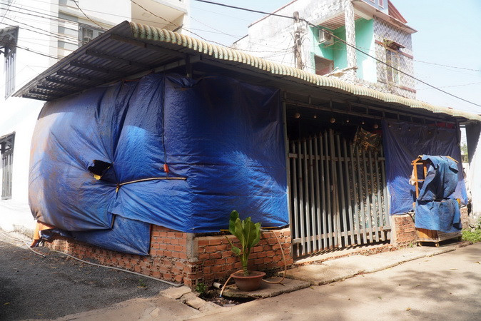 Người dân xã Bình Sơn, huyện Long Thành, tỉnh Đồng Nai buộc phải dùng bạt che nhà để chắn bụi đỏ vào bên trong.