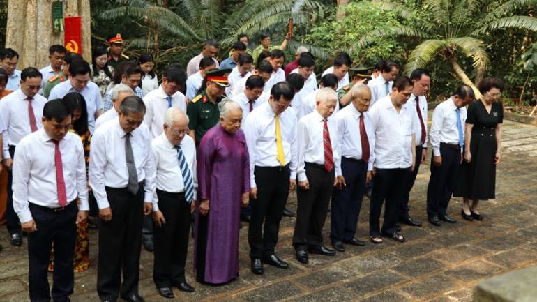 Các đại biểu dành một phút mặc niệm tại nhà bia trung tâm di tích Trung ương Cục miền nam.