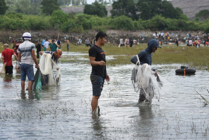 Người dân sử dụng lưới để bắt cá tại khu vực chân đập tràn phía hạ lưu.