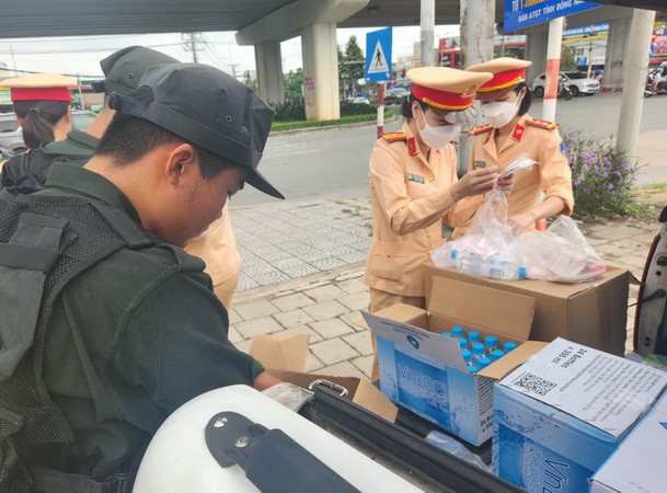 Cán bộ Cảnh sát giao thông Công an tỉnh Đồng Nai chuẩn bị nước suối, khăn lạnh để phát cho người dân.