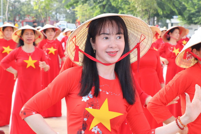 Khuôn mặt rạng ngời của một phụ nữ tham gia biễu diễn xếp hình nghệ thuật bản đồ đất nước ta trên nền nhạc các ca khúc về quê hương đất nước, con người Việt Nam.