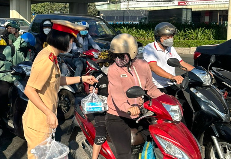 Chiến sĩ Cảnh sát giao thông đội nắng tiếp sức người dân đi xe máy về quê nghỉ lễ.