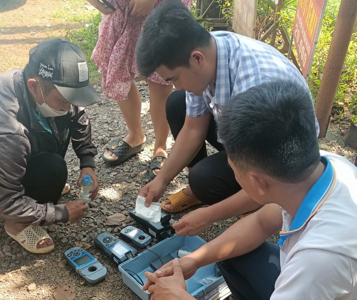 Lấy mẫu nước để làm rõ nguyên nhân cá chết ở suối Bí.