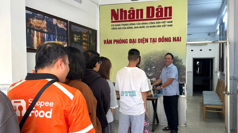 Bạn trẻ xếp hàng nhận phụ san đặc biệt ở Văn phòng đại diện Báo Nhân Dân tại Đồng Nai.